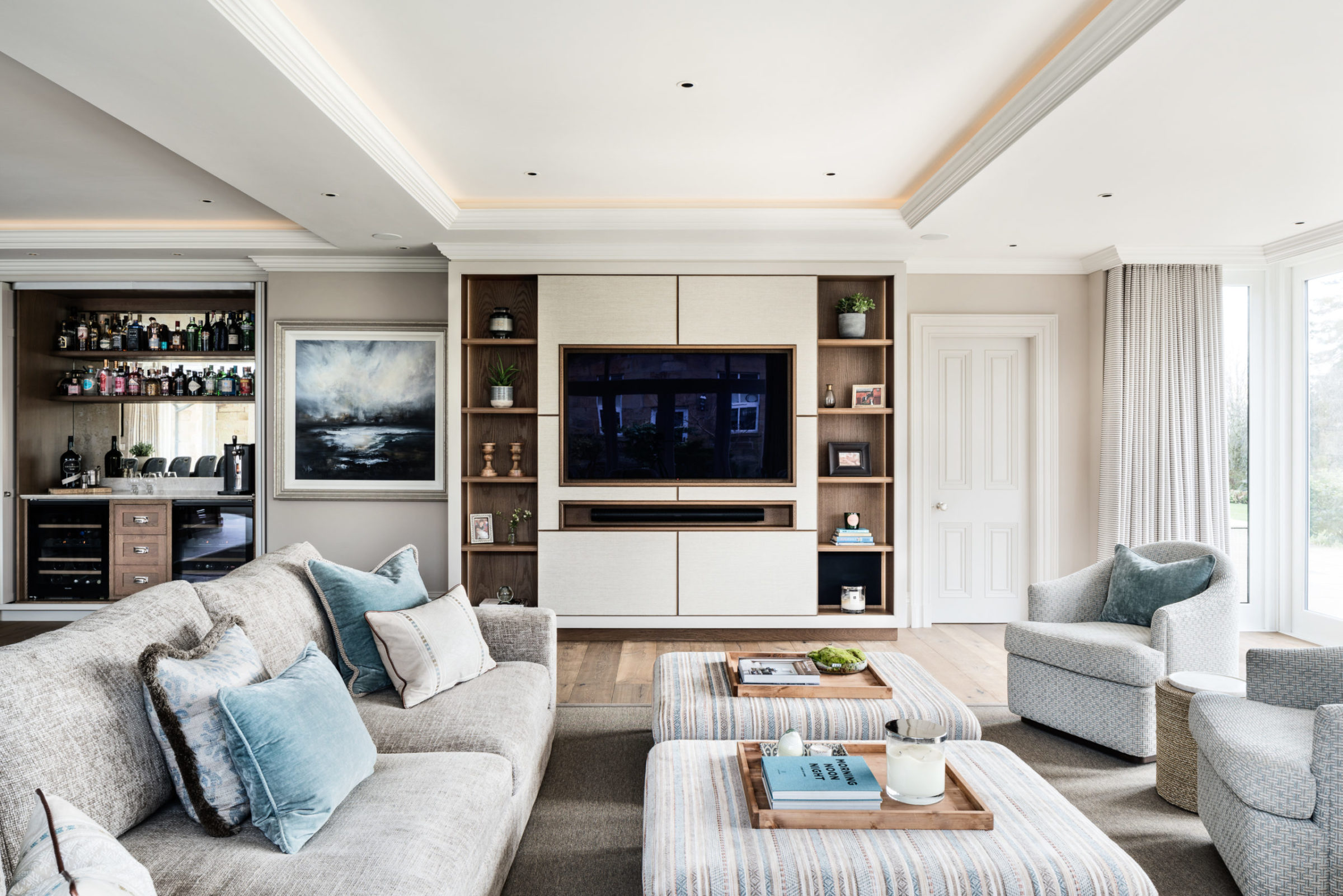A smart lounge with a media unit, bar area, and soft furnishings.