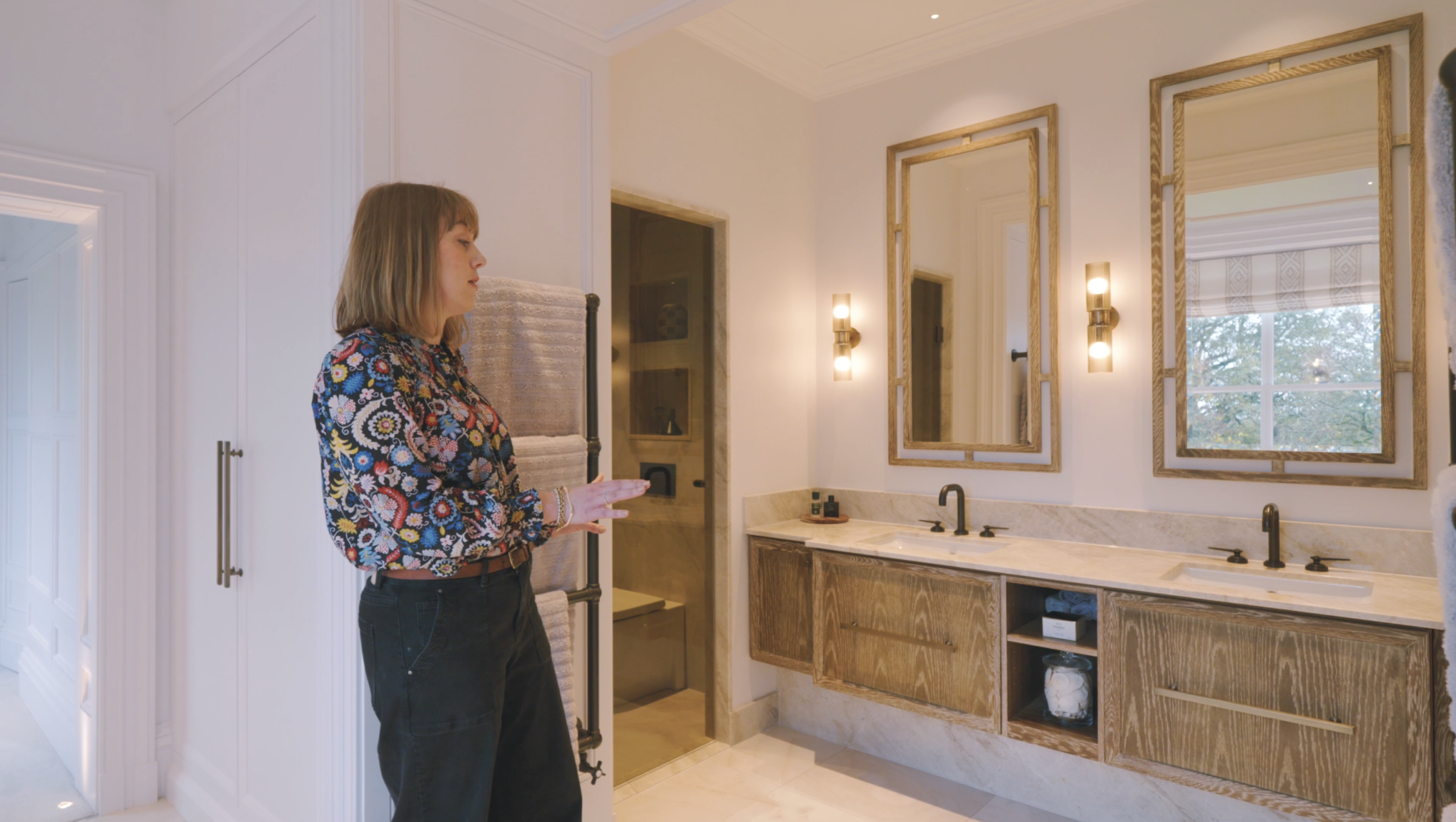 Helen in the bathroom with bespoke large mirrors and sink unit