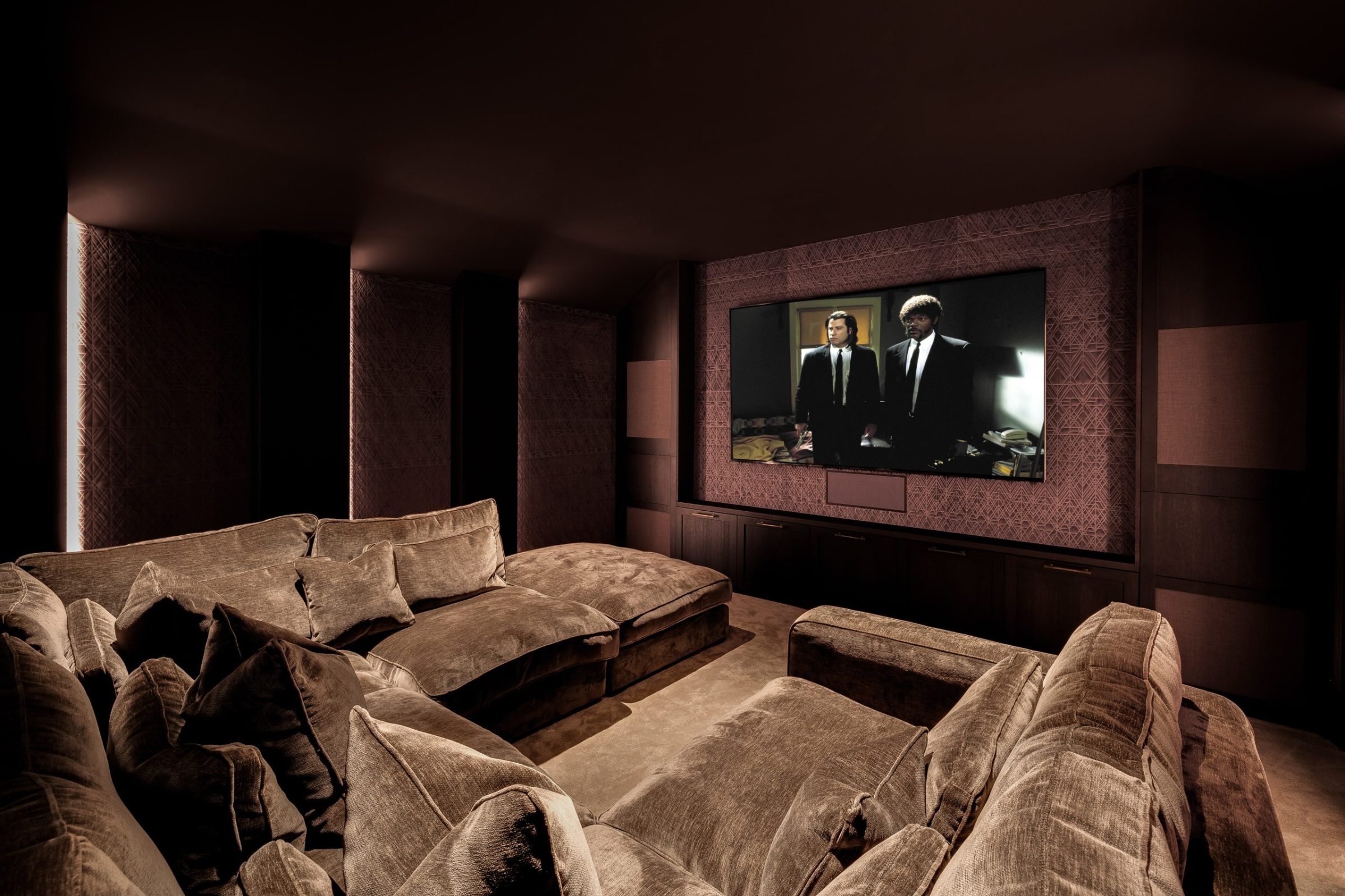 Cinema room with velvet modular sofas, wall panelling and integrated screen
