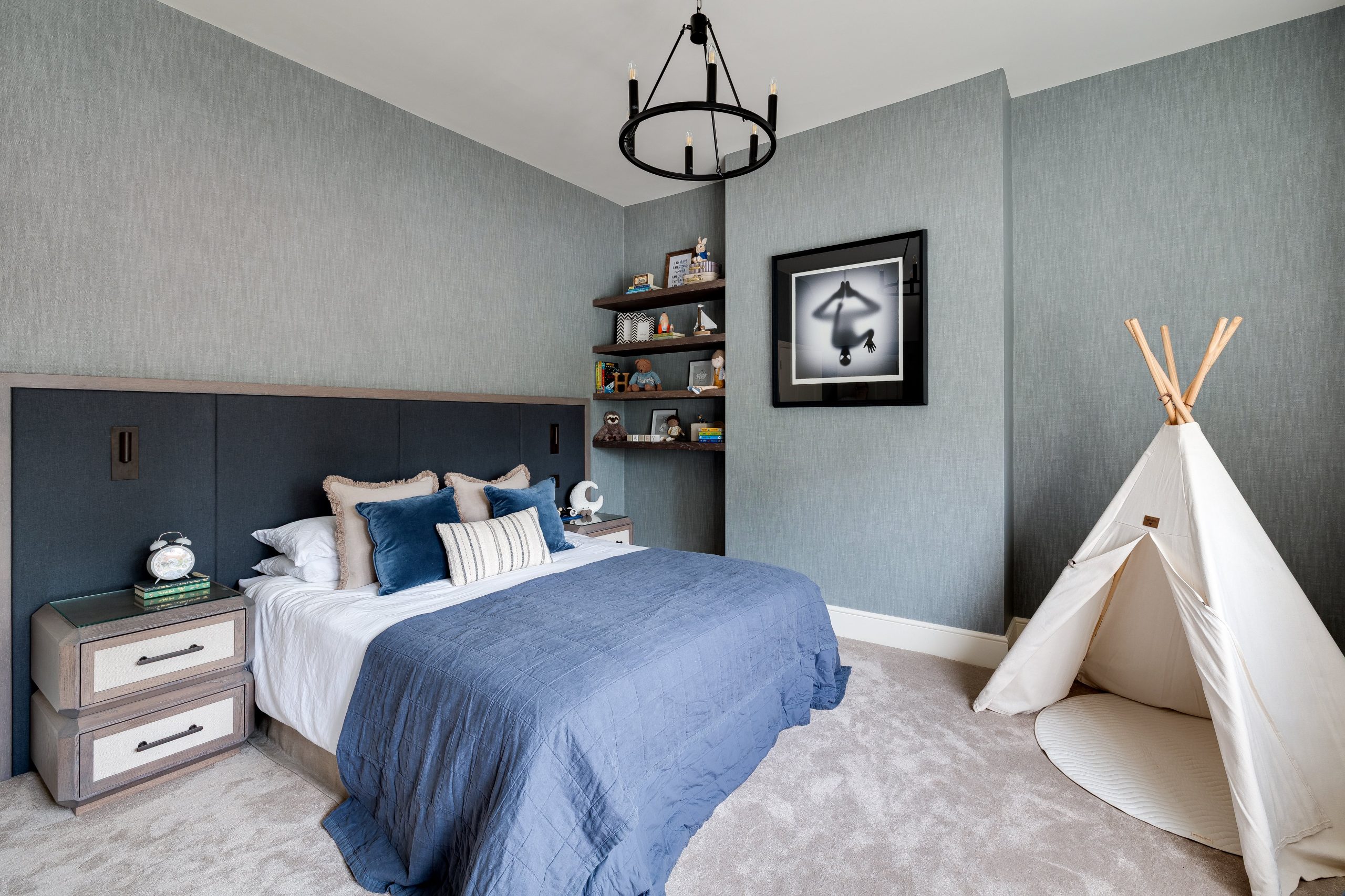 Children’s bedroom with soft grey walls, statement headboard and play teepee