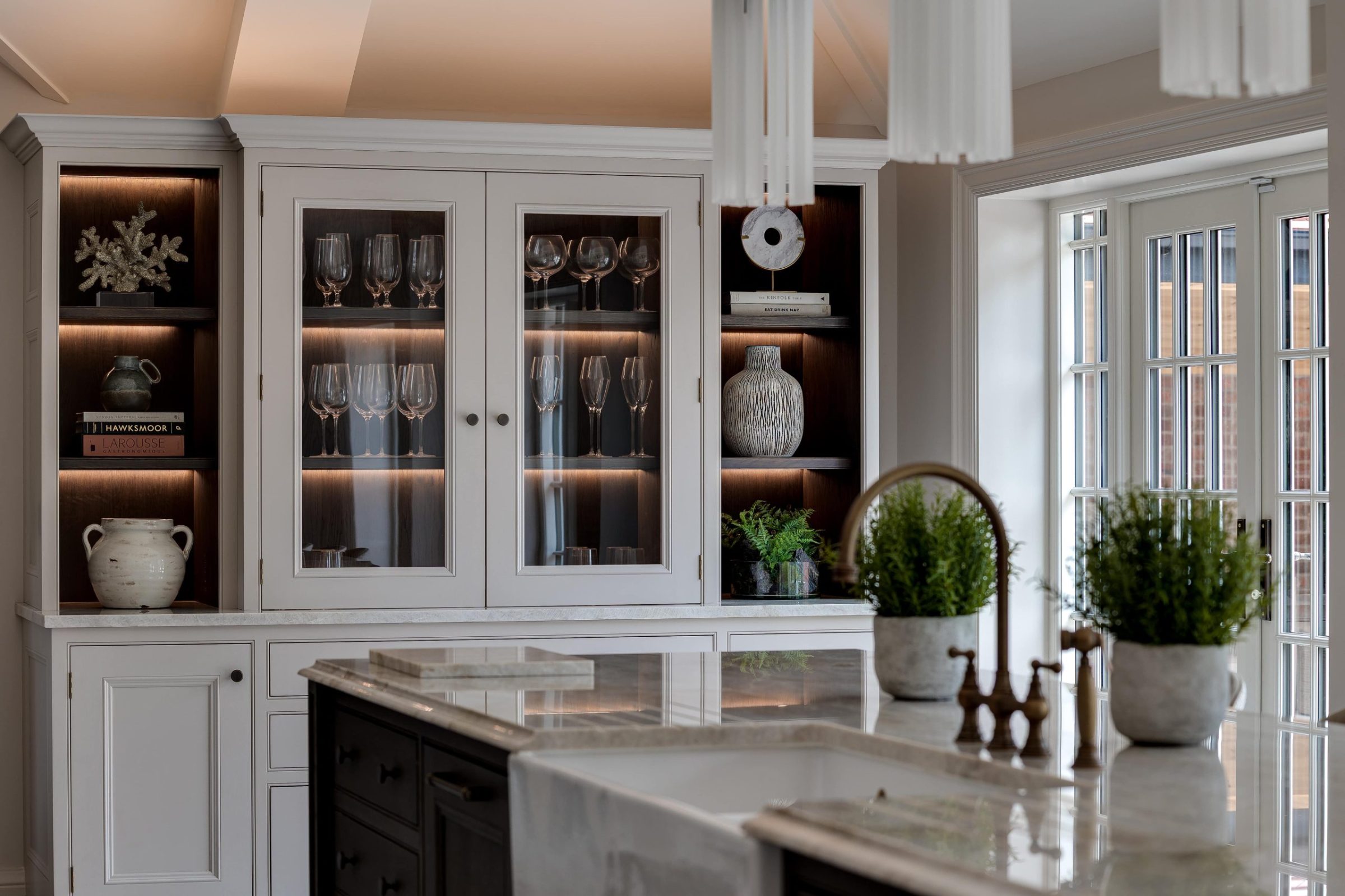Kitchen display cabinetry with glass-fronted doors and warm lighting detail