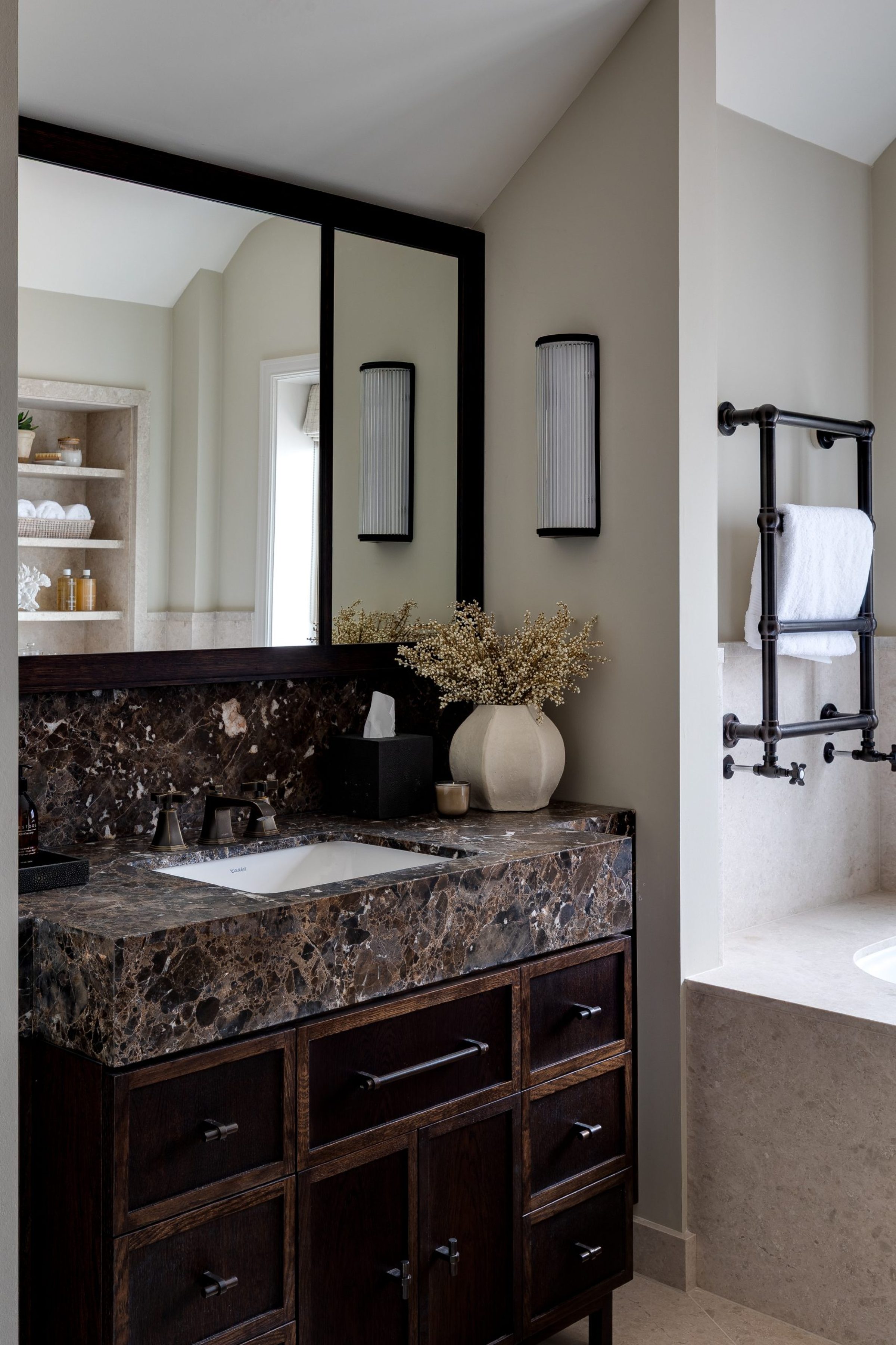 Dark timber vanity unit with marble top and integrated storage in master bathroom